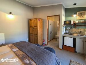 a bedroom with a bed and a kitchen at Suikerbosch Room 1 and Room 2 in Dullstroom