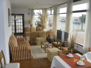 a living room with chairs and a tv and a table at Onais Hotel in Mar de Ajó