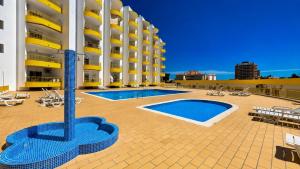a large building with a swimming pool in front of it at Mar & Sol Penthouse in Portimão