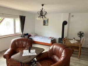 a living room with two chairs and a table and a bed at Duży komfortowy apartament in Grajewo