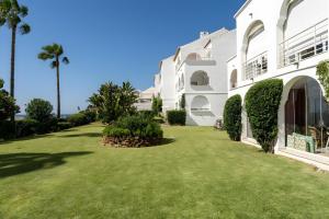 a large white building with a green yard at 240 Front line beach La Cala in La Cala de Mijas