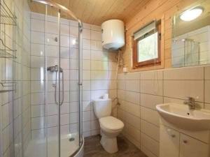 a bathroom with a toilet and a shower and a sink at Domki Mucki in Międzywodzie +8 photos