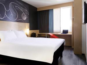 a hotel room with a large white bed and a window at Ibis Mexico Alameda in Mexico City +63 photos