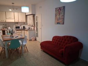 a living room with a red couch and a table at FRIDA APARTMENT remis gratis a Ezeiza in Ezeiza
