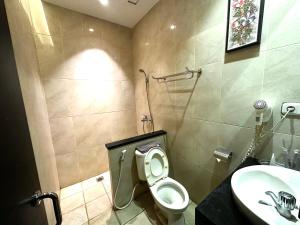 a bathroom with a toilet and a sink at Hotel De Green Lampung in Lampung