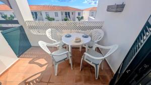 a patio with a table and chairs on a balcony at Paradise COSTA ARENAL in Es Mercadal
