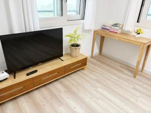 a flat screen tv on a wooden stand in a living room at 깨비하우스201 in Wŏlsan