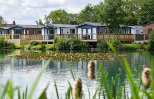 a house on the edge of a lake at Robin Lodge in Amotherby