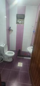 a bathroom with a toilet and a sink and a clock at الاردن - جرش in Jerash