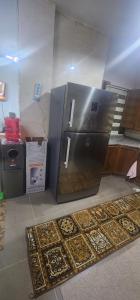 a kitchen with a refrigerator and a rug on the floor at الاردن - جرش in Jerash