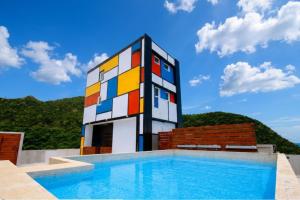a building with a pool in front of a house at House16 in Green Island