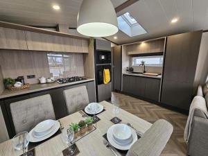 a dining room with a table and a kitchen at Robin Lodge in Amotherby