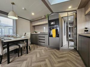 a kitchen and dining room with a table and a refrigerator at Robin Lodge in Amotherby +5 photos