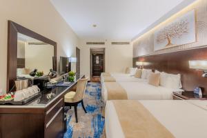 a hotel room with two beds and a desk at The Venue Al Harithia Hotel in Medina +83 photos