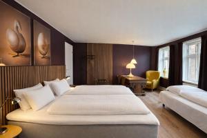 a hotel room with a large bed and a chair at Hotel Schaumburg in Holstebro +30 photos
