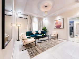 a living room with a blue couch and chairs at HOMETEL An Nahdah in Jeddah