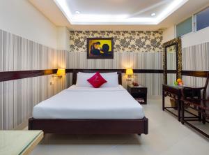 a bedroom with a large bed with a red pillow at Pink Horizon Saigon Airport Hotel in Ho Chi Minh City +24 photos