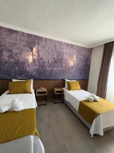 a bedroom with two beds and a purple wall at Quatro Life Hotel in Bodrum City +39 photos