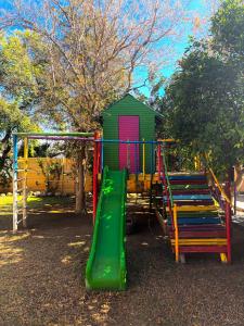 a playground with a green slide in a park at Capbon Guesthouse in Windhoek
