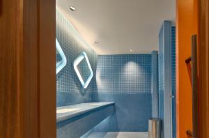 a blue bathroom with a sink and a mirror at Go Hotel Khon Kaen Campas in Ban Nong Waeng +16 photos
