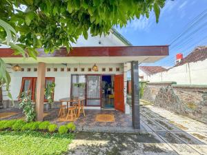 a small white house with a table and chairs at ŚamaStay in Yogyakarta +21 photos