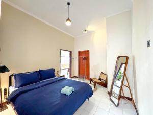 a bedroom with a blue bed and a ladder at ŚamaStay in Yogyakarta