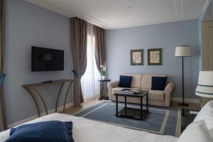 a hotel room with a bed and a couch at Turin Palace Hotel in Turin
