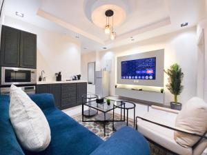 a living room with a blue couch and a kitchen at HOMETEL An Nahdah in Jeddah +162 photos