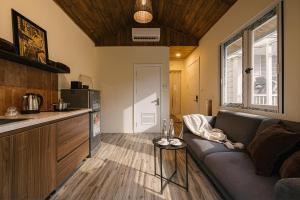 a living room with a couch and a kitchen at Modapick Bạch Đằng - Living in the nature garden with full river view in Hanoi