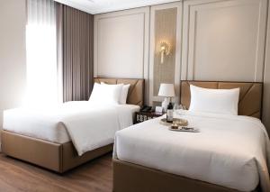 a hotel room with two beds and a window at Radiant Hotel and Events in San Fernando