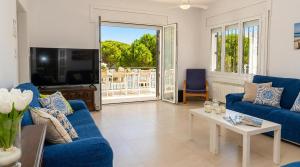 a living room with blue couches and a tv at Villa Playa del Sur A 250 metros de una magnifica playa Capacidad más de 16 AC 6 Suites Piscina XL in Torredembarra +51 photos