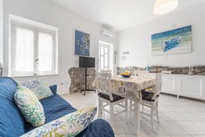 a living room with a blue couch and a table at Al centro del Borgo in Calasetta