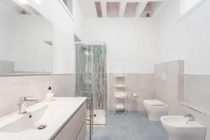 a white bathroom with a sink and a toilet at Al centro del Borgo in Calasetta
