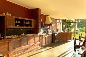 a kitchen with red walls and wooden cabinets and a table at Gästehaus Kloster Nimbschen in Grimma +18 photos