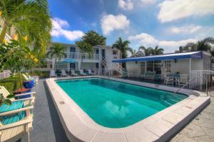 a swimming pool in front of a house at May-Dee Suites in Florida in Hollywood