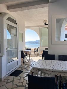 a room with a table and chairs and a view of the ocean at Family Majčica - villa Malo Misto in Klek