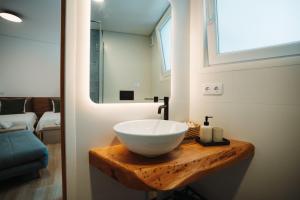 a bathroom with a bowl sink on a wooden counter at Estação do Parque in Santa Maria Da Feira +33 photos