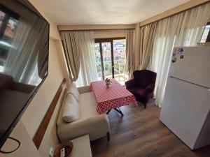 a small kitchen with a table and a refrigerator at Atlas Apart Hotel in Çeşme
