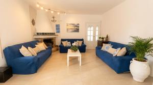 a living room with blue couches and a table at Villa Playa del Sur A 250 metros de una magnifica playa Capacidad más de 16 AC 6 Suites Piscina XL in Torredembarra
