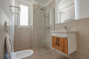 a bathroom with a toilet and a shower and a sink at Queen Residence & Hotel in Shëngjin +27 photos