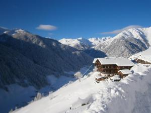 un lodge de esquí en una montaña nevada con montañas cubiertas de nieve en Bergbauernhof Ausserberglet en Innervillgraten