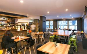 a restaurant with wooden tables and green chairs at Altitude Apartments in Falls Creek