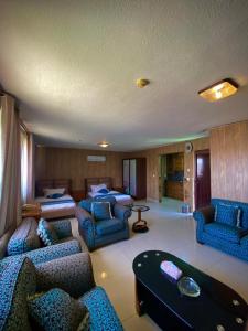 a large living room with blue chairs and a couch at Al Mansi hotel in Amman