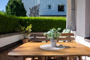 a wooden table with a vase of flowers on a patio at Seefeld ALPIN Apartments in Seefeld in Tirol