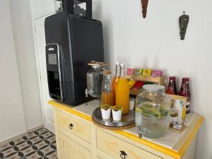 a counter with a coffee maker and a microwave at NG Guest House Ammentos in Olbia