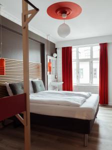 a bedroom with a large bed with red curtains at Annex Copenhagen in Copenhagen
