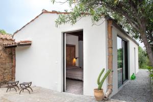 a white house with a cactus in the doorway at Tenuta Luogo Marchese in Pollina