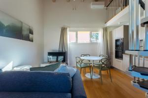 a living room with a blue couch and a table at Yourbanflat Ring River in Padova