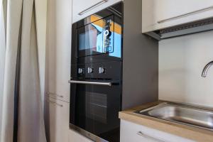 a black oven in a kitchen next to a sink at Yourbanflat Ring River in Padova +12 photos