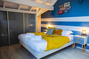 a bedroom with a bed with a blue wall at Gite de Mortagne, Villa avec Piscine in Gigny-sur-Saône